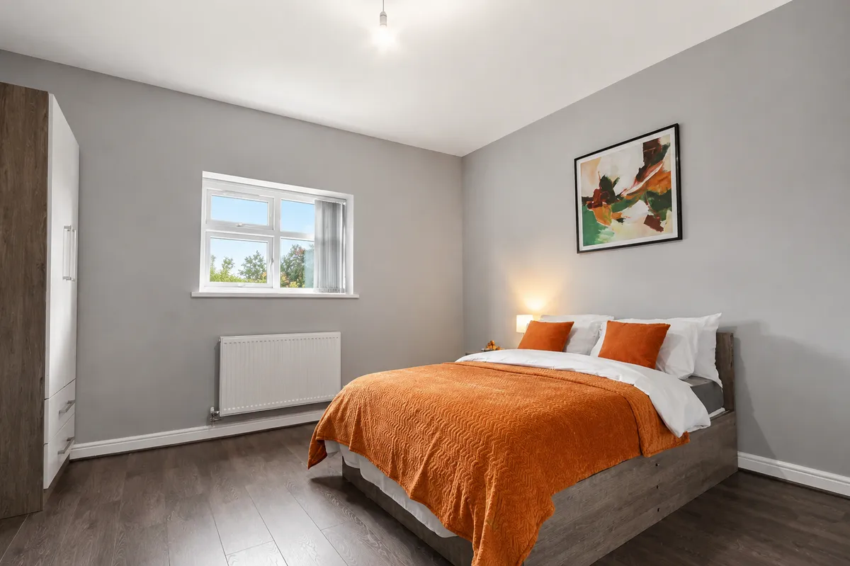 Double bedroom with a wardrobe, bedside lamp and made-up bed